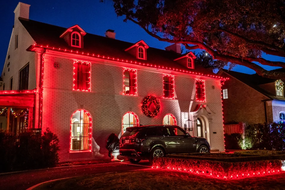 Red and warm white architectural Christmas lighting on a home