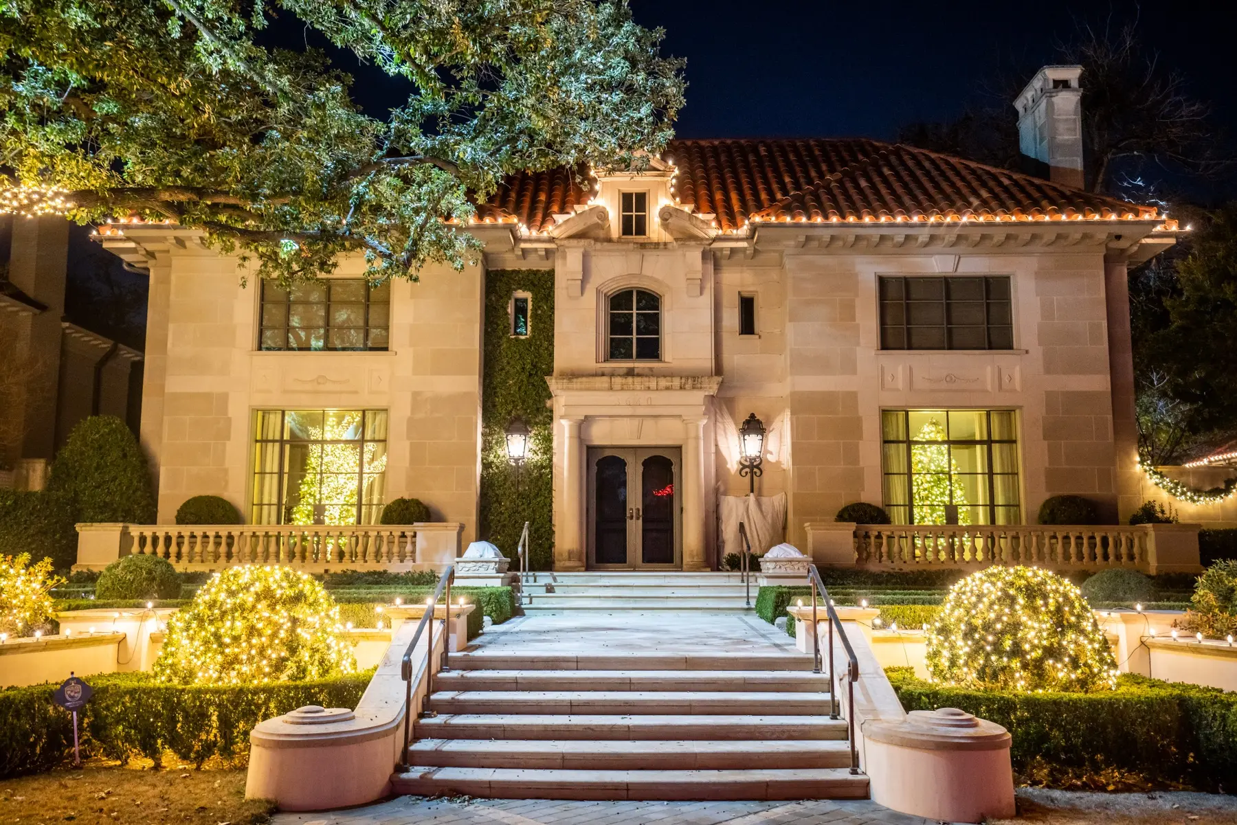 Large residence with warm white tree, landscape and pathway holiday lighting