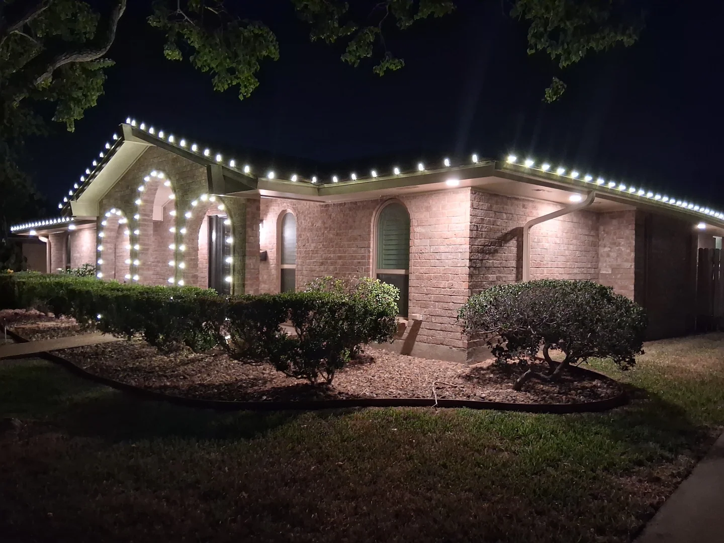 Single-story brick home with precise warm white C9 roofline lighting